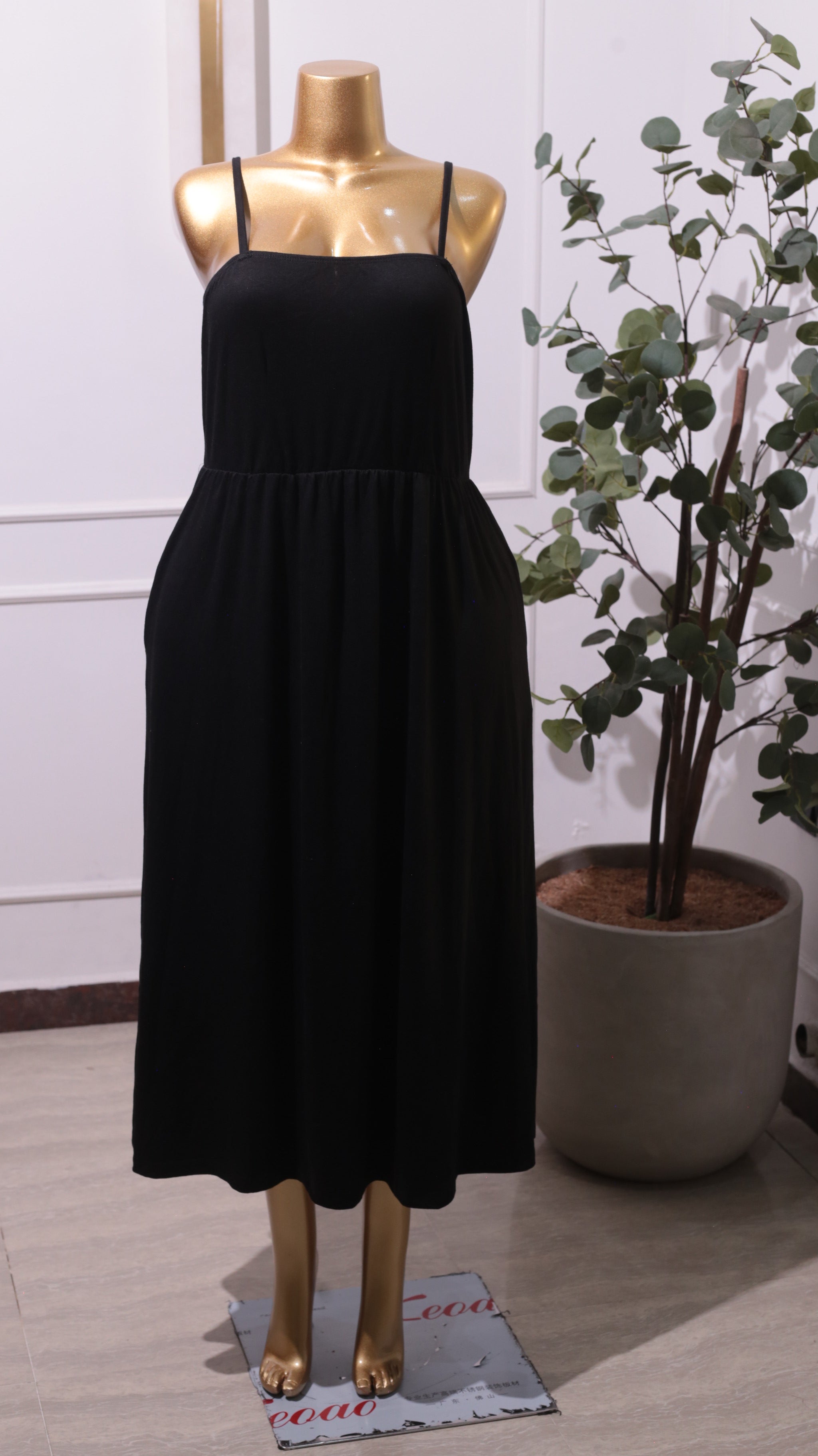 A Black Smocked Bodice Midi Dress With Adjustable Spaghetti Straps