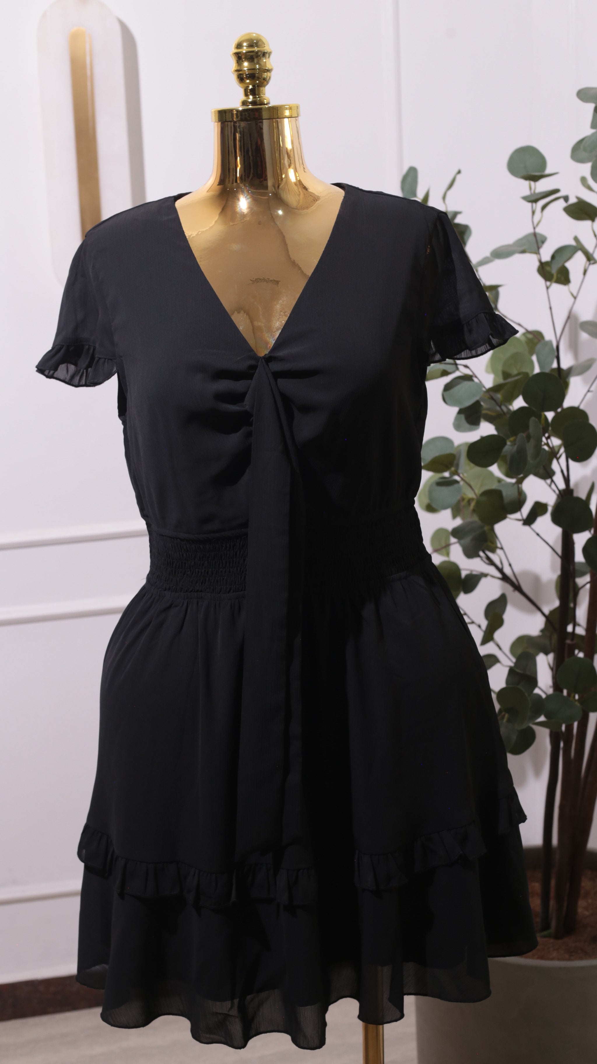 A Black Mini Dress With A Smocked Stretchy Waist And Tiered Ruffles