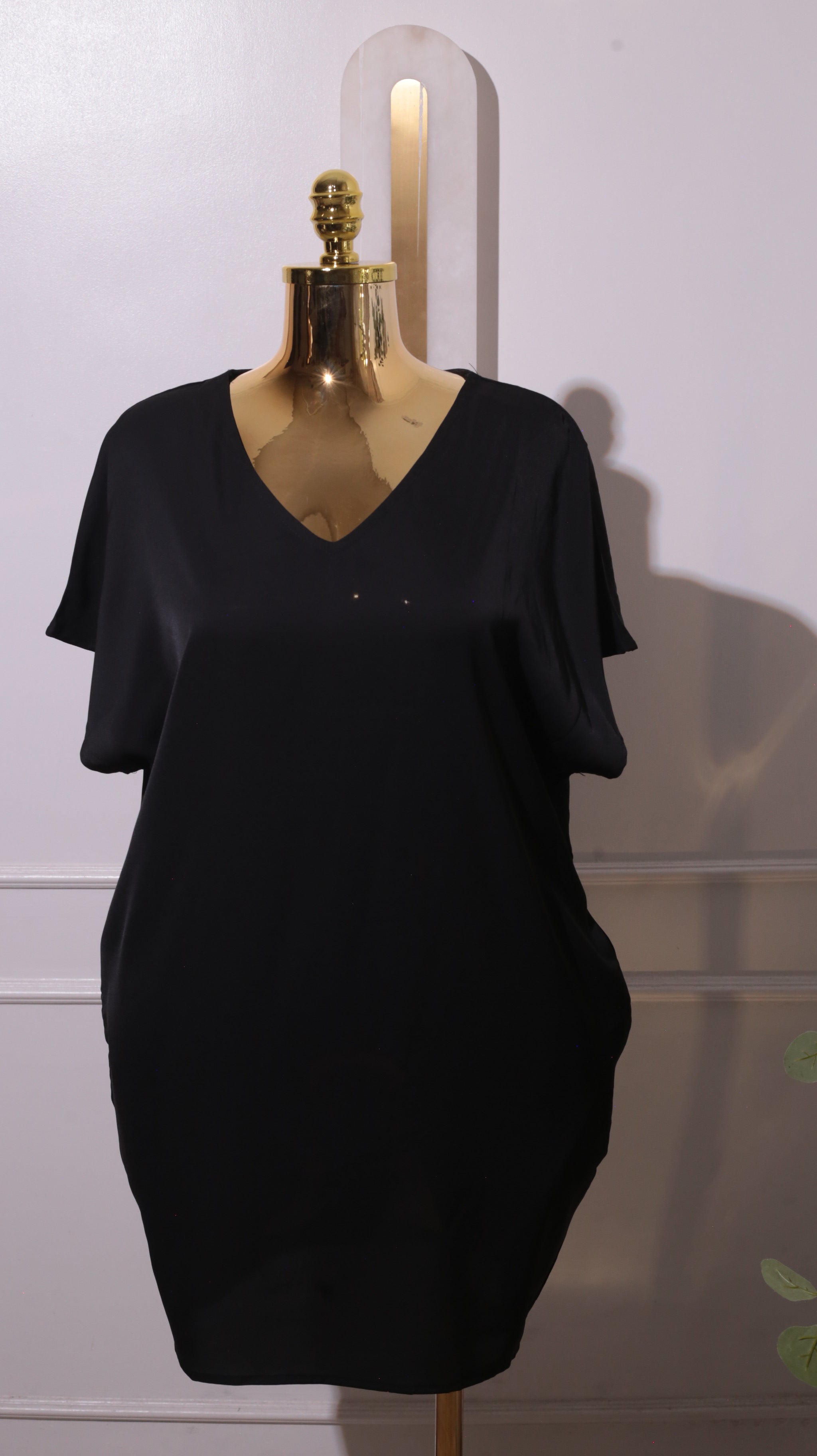 A Black Short-sleeved V-neck Dress, Possibly Made Of Silk Or A Silk Blend