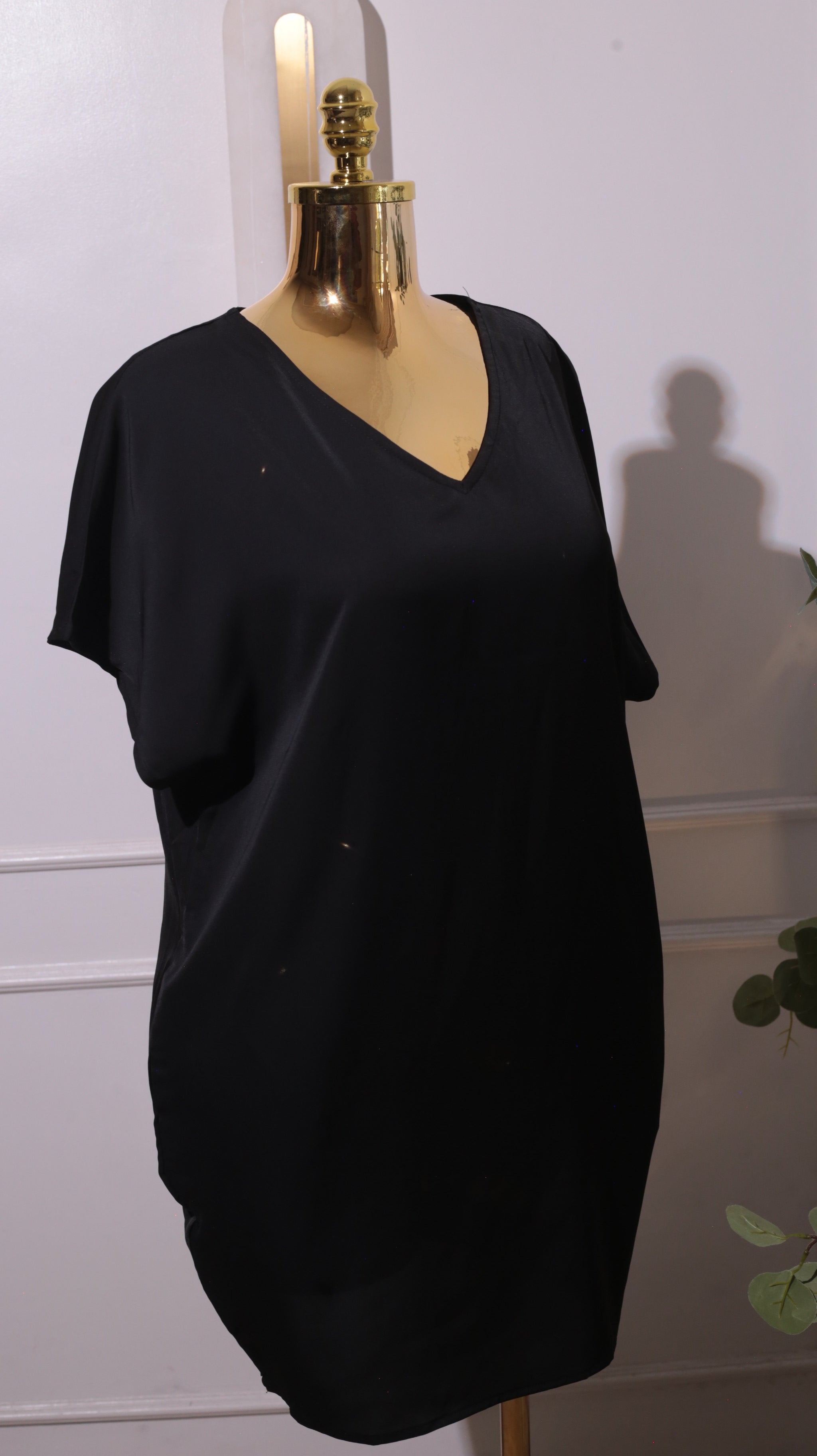 A Black Short-sleeved V-neck Dress, Possibly Made Of Silk Or A Silk Blend