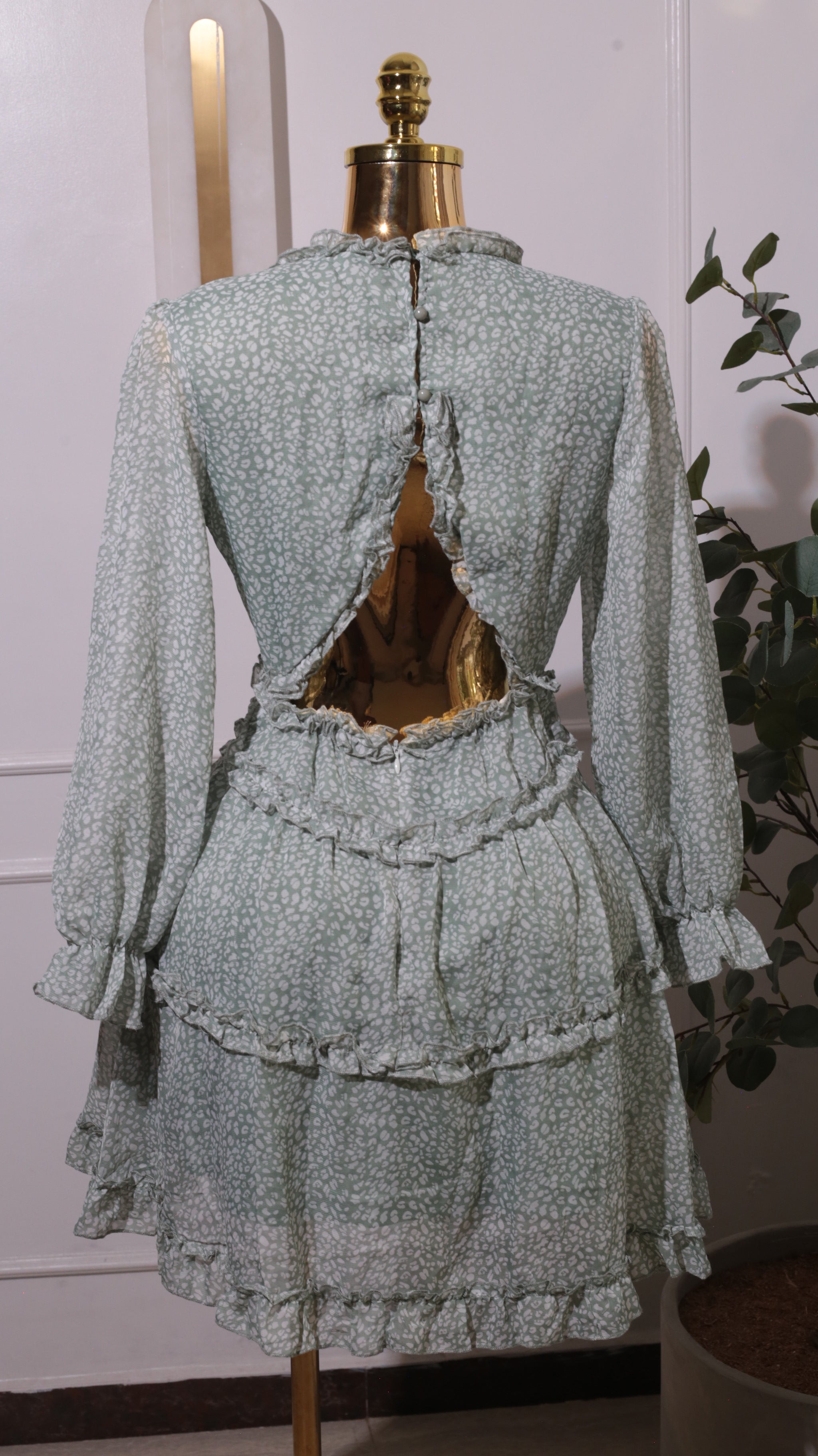 A Green Floral Mini Dress With A V-neck, Long Sleeves, A Shirred Waist, And Ruffled Tiers